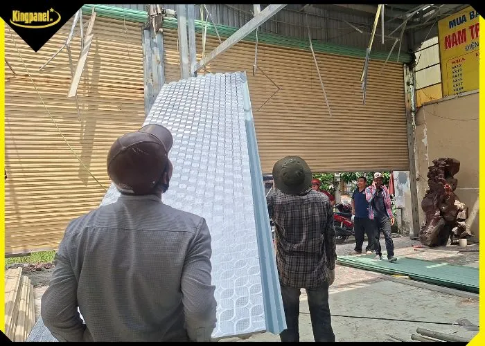 Thợ công trình chuẩn bị đưa tôn PU 3 lớp lên lợp mái.