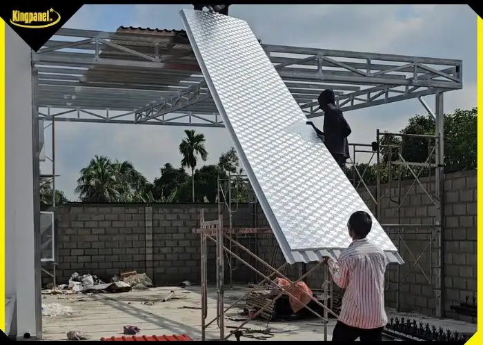 Thợ thi công đang tiến hành lợp tấm tôn PU cách nhiệt 3 lớp chống nóng cho khung mái nhà thép.