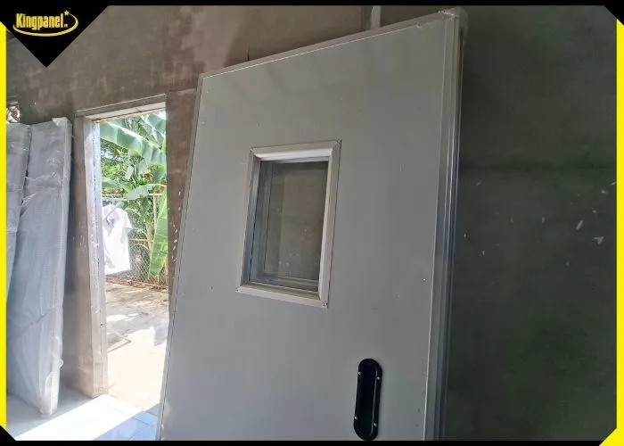 Hình ảnh thực tế cửa panel 1 cánh có ô kính cách nhiệt sau khi lắp đặt hoàn thiện tại nhà xưởng.